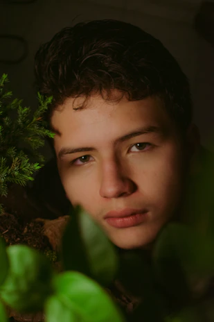 A serene moment of a teen meditating outdoors, surrounded by gentle greenery.