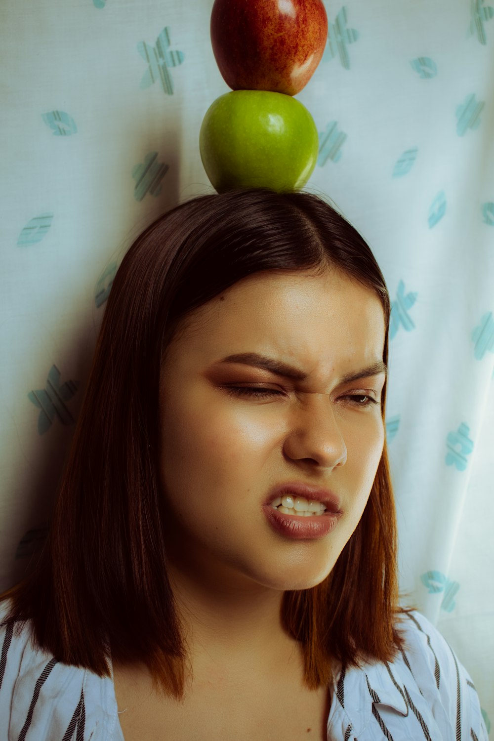 woman with green apple on her head