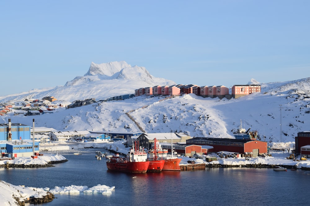 navio vermelho e branco no mar perto da montanha durante o dia
