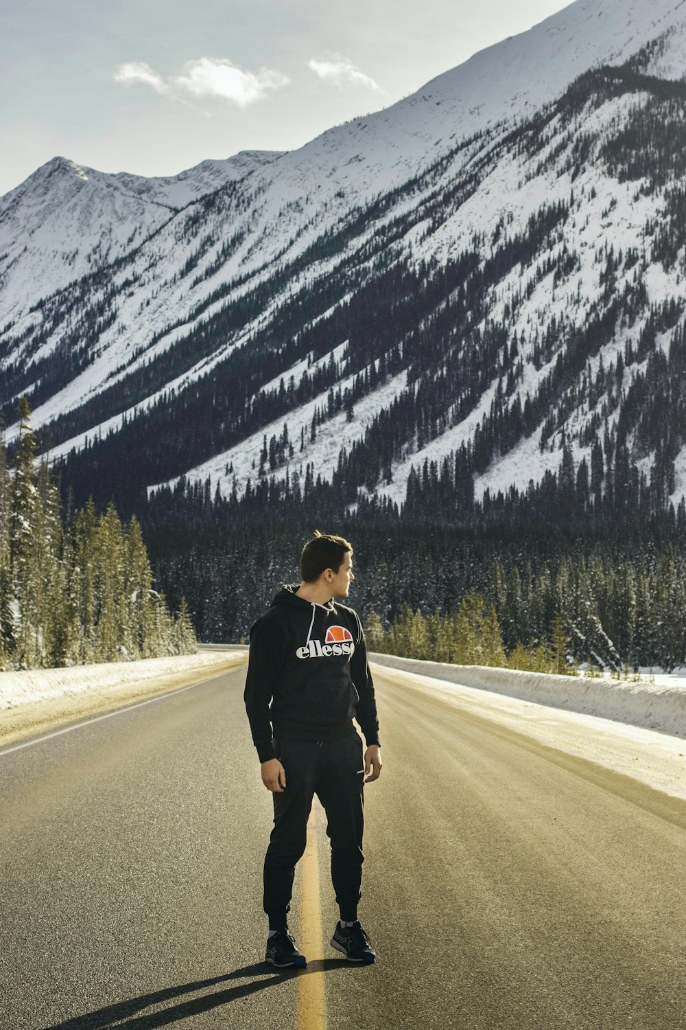 man in black jacket standing on road during daytime