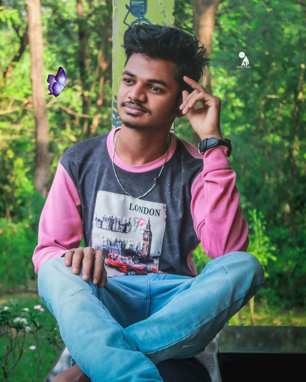 man in pink and gray long sleeve shirt sitting on green grass field