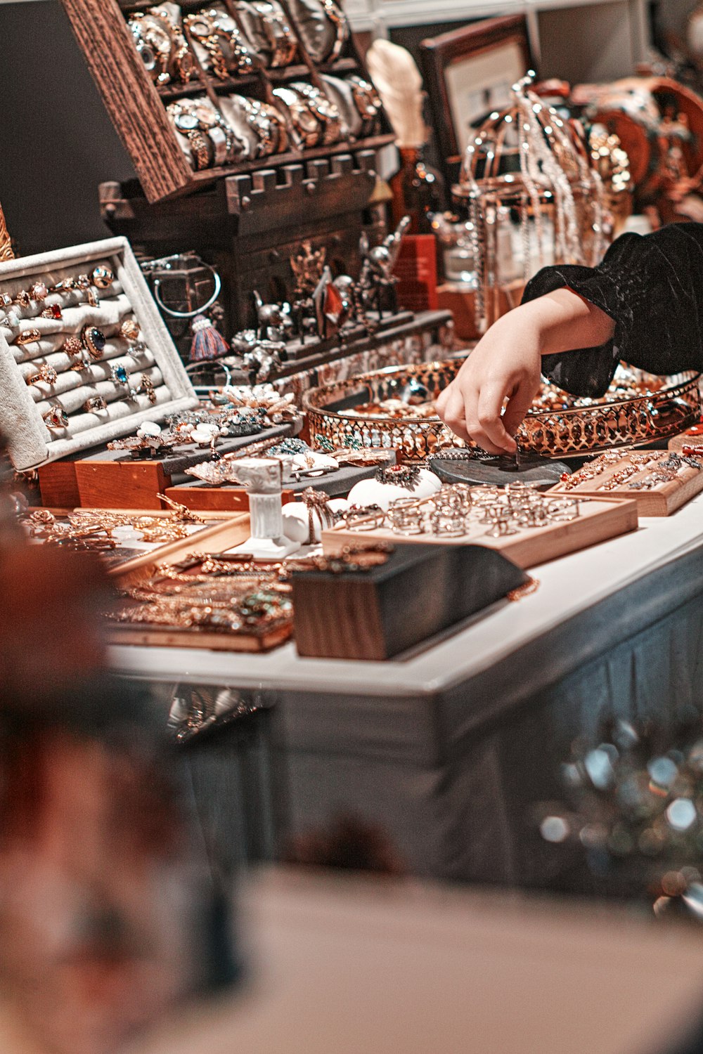 person in black shirt standing in front of brown wooden table with brown and white wooden