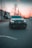 A sleek luxury car parked at a minimalist urban street during twilight.