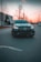 A sleek luxury car parked at a minimalist urban street during twilight.