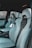 The interior of a car featuring luxury sports seats with a sleek design. The seats are predominantly light grey with black accents and have noticeable logos on the headrests. There is a spacious middle console and visible car doors showcasing a modern and upscale finish.