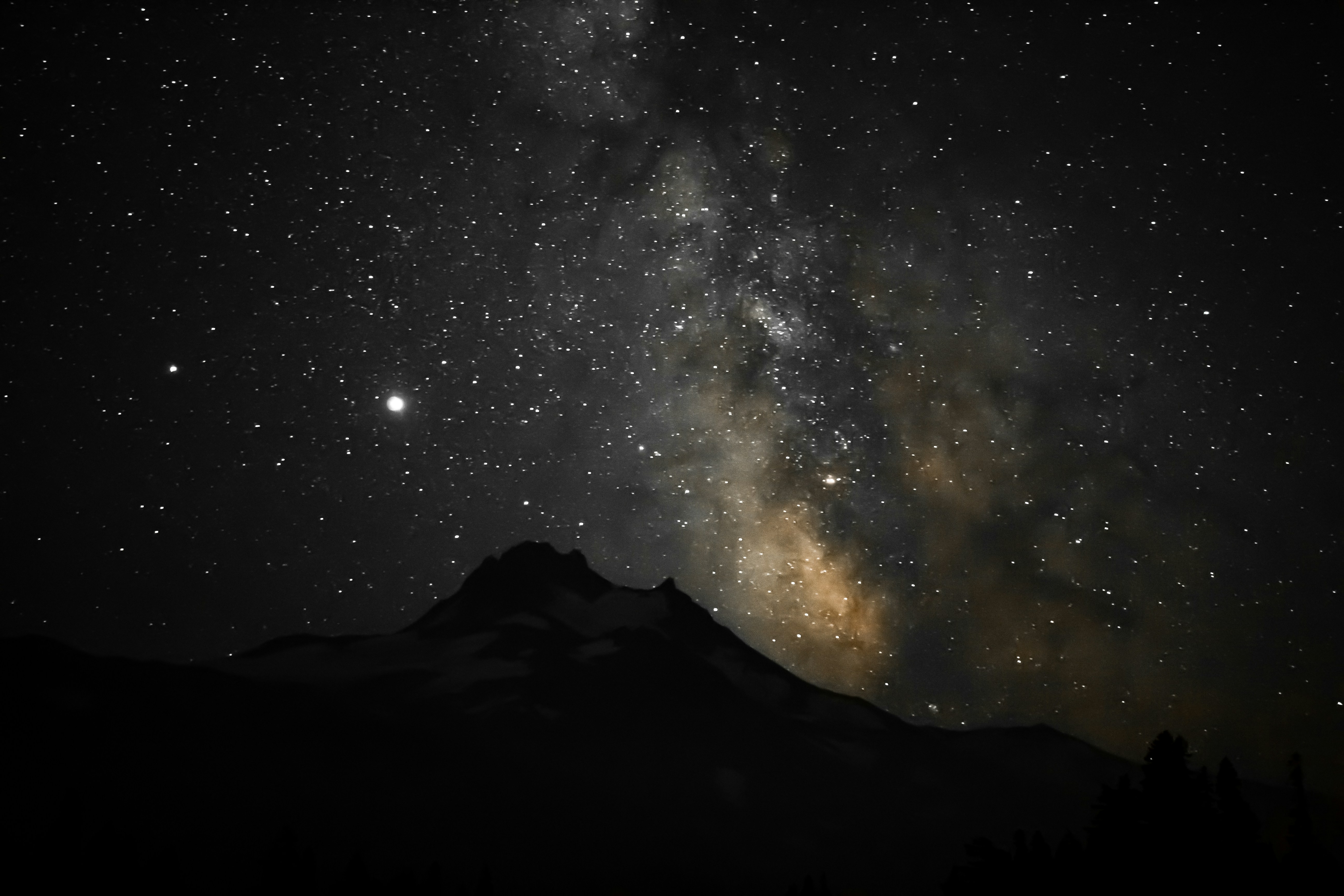 silhouette of mountain under starry night