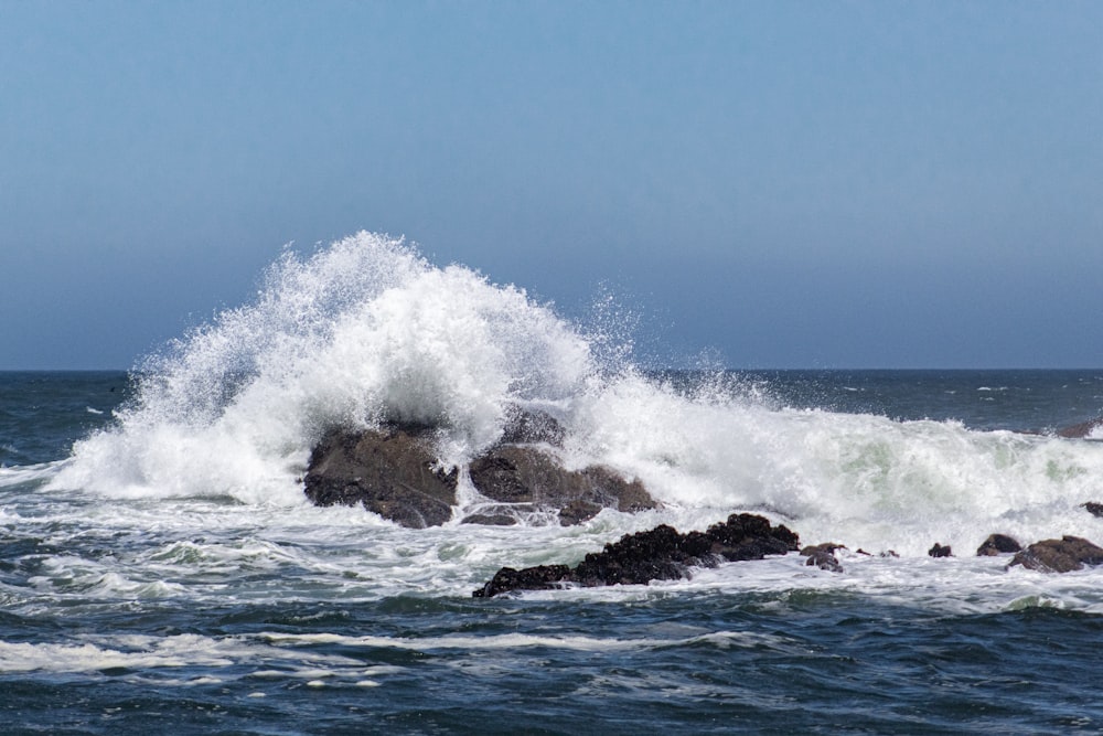 ocean waves crashing on brown rock