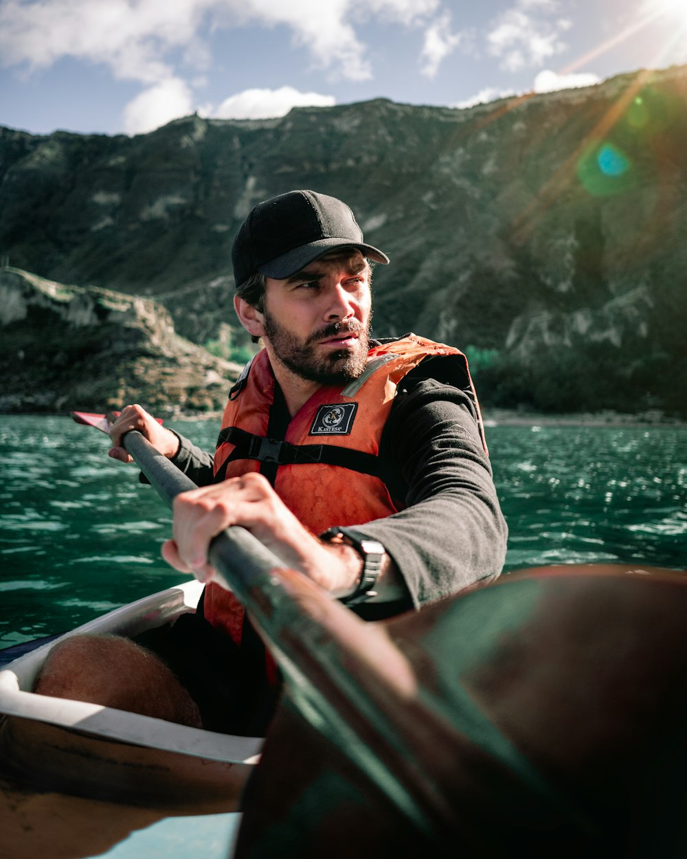 man in red and black striped polo shirt riding on boat during daytime