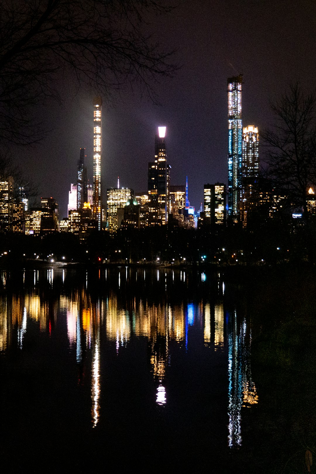 city skyline across body of water during night time