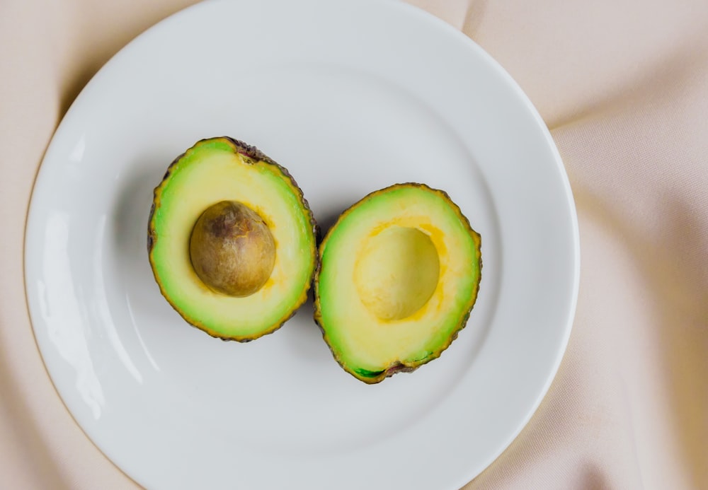 sliced avocado fruit on white ceramic plate