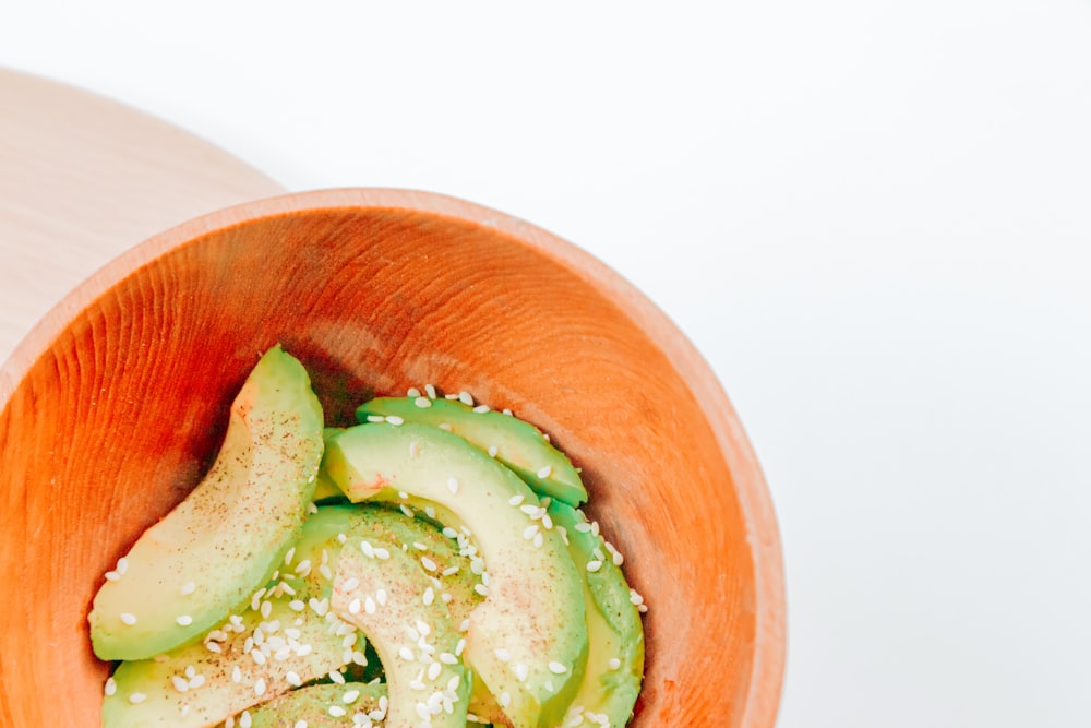 sliced cucumber in brown wooden bowl