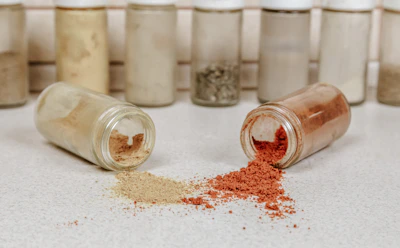 Rustic spice blend jars spilling golden and red powders with a baseball bat leaning casually nearby.