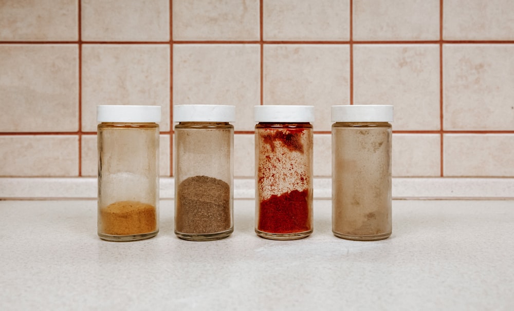 three clear glass jars with brown powder inside