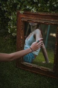 person holding brown wooden frame