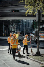 people in orange coat walking on sidewalk during daytime
