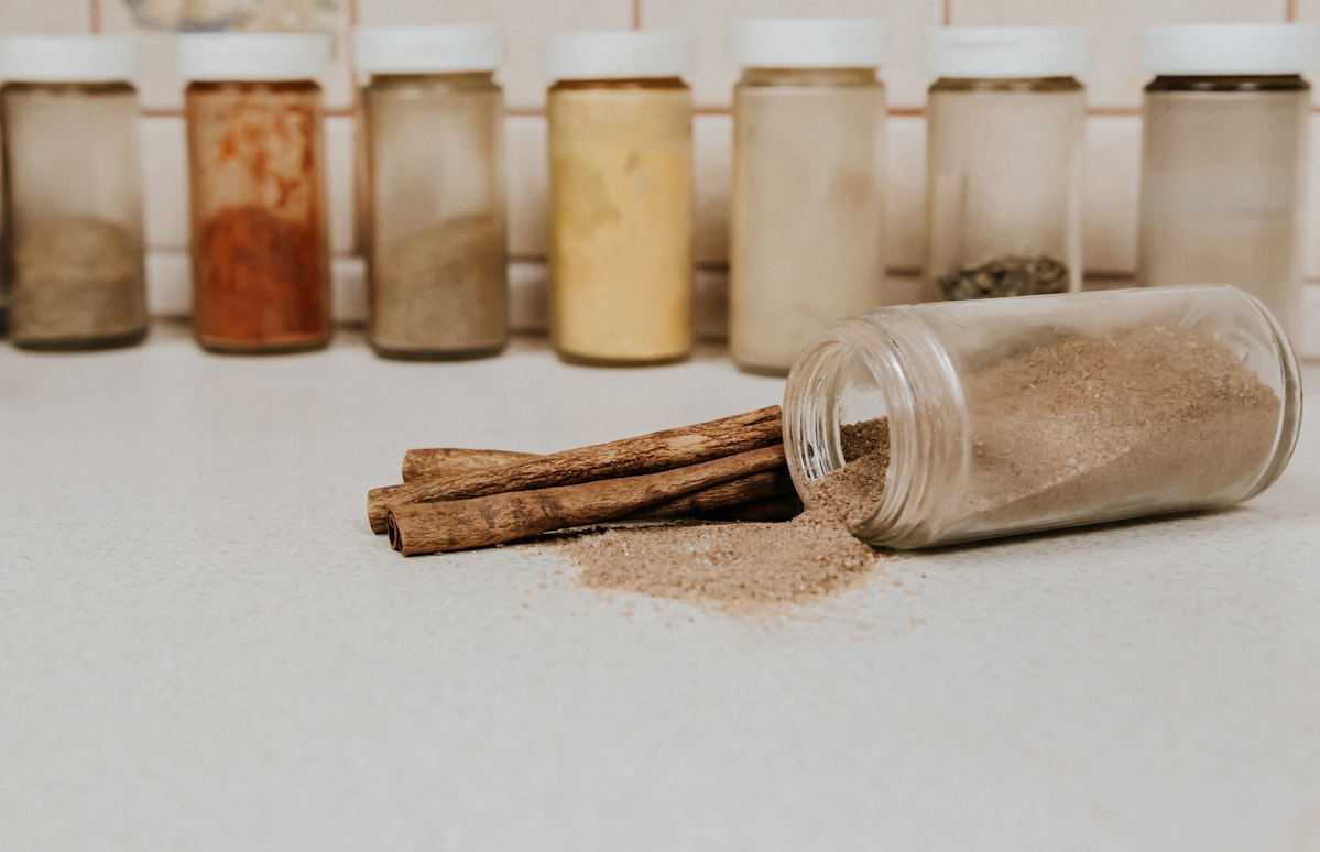 A jar of Scattered Cinnamon on a background of spices. Advertising