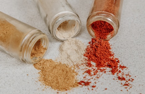 Fine metal powders in small glass containers on a wooden table