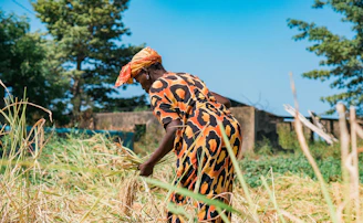 woman in black and white floral dress standing on brown grass field during daytime