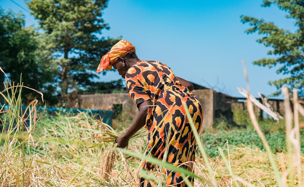 woman in black and white floral dress standing on brown grass field during daytime