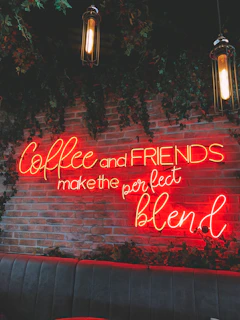 A group of friends laughing and chatting over freshly brewed coffee at a rustic wooden table.