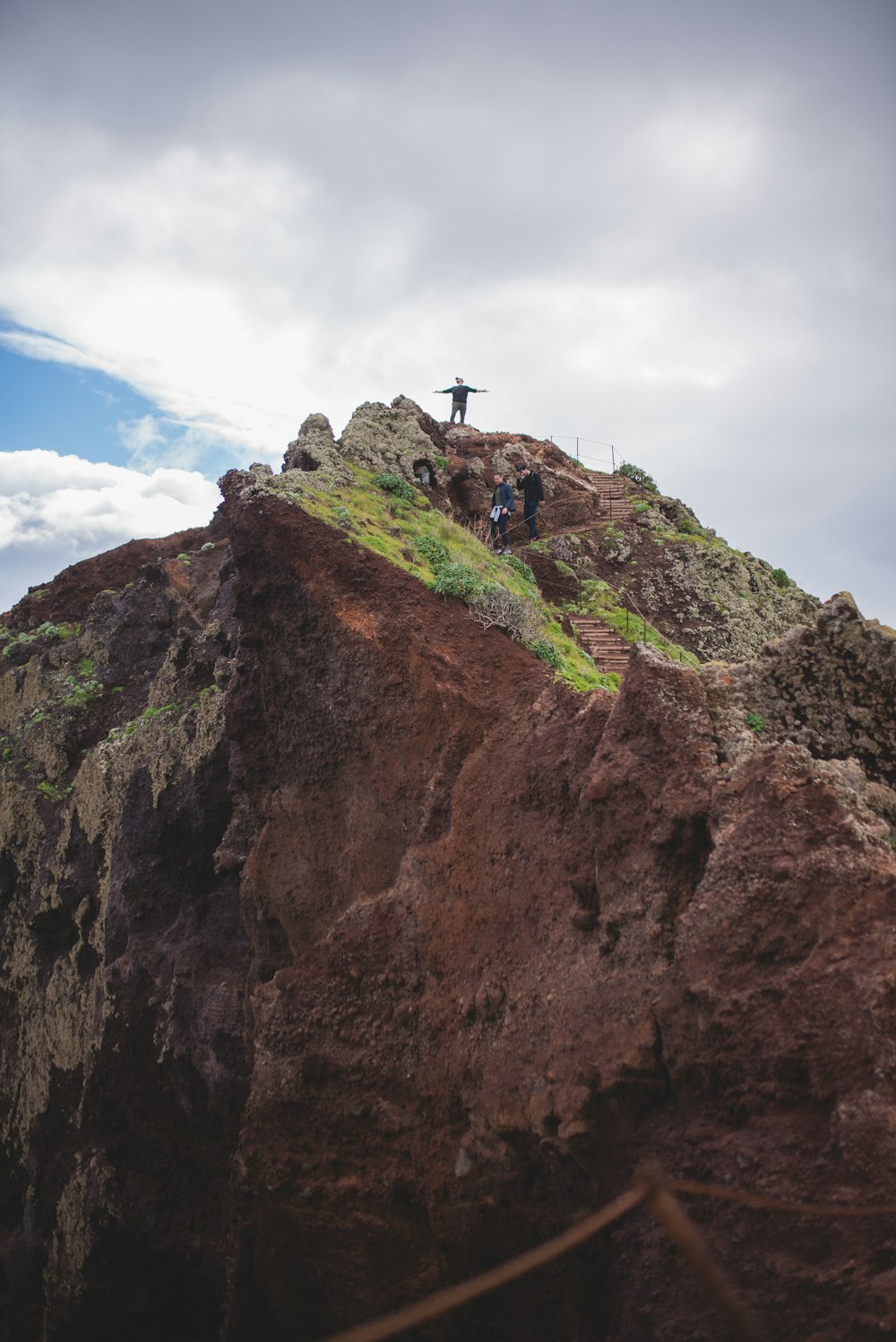 person standing on brown rock formation under blue sky during daytime