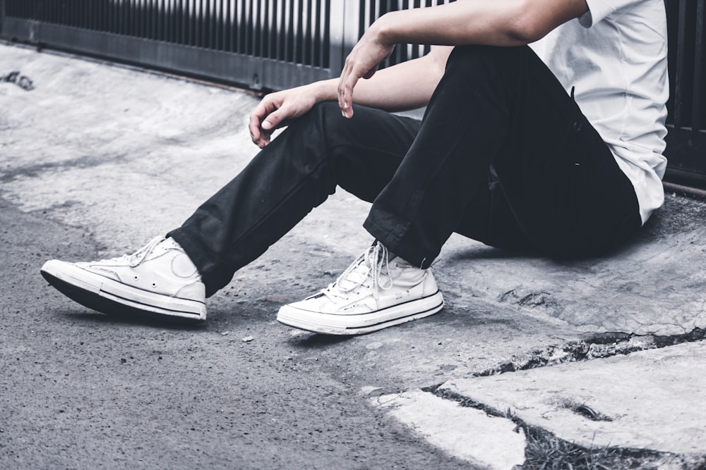 person in black pants and white sneakers