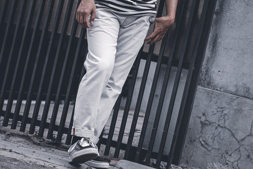 person in white pants and black and white nike sneakers