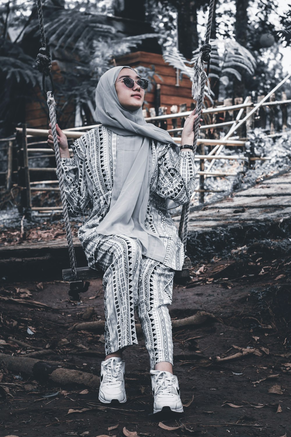 woman in white and black hijab sitting on swing