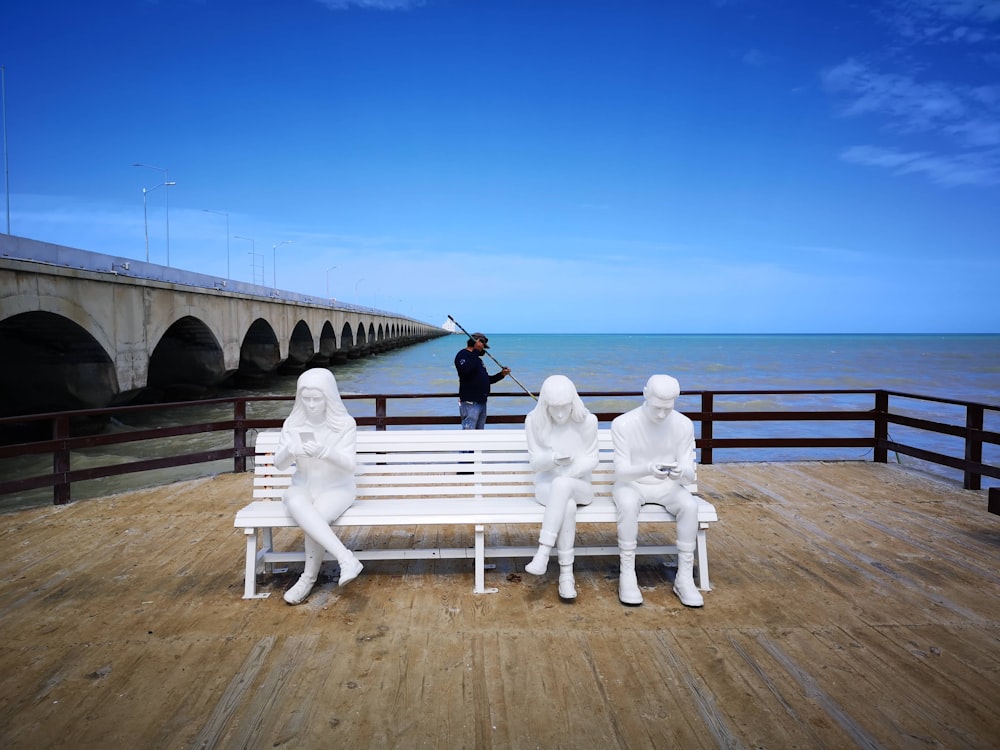 Estatua blanca en muelle de madera marrón durante el día