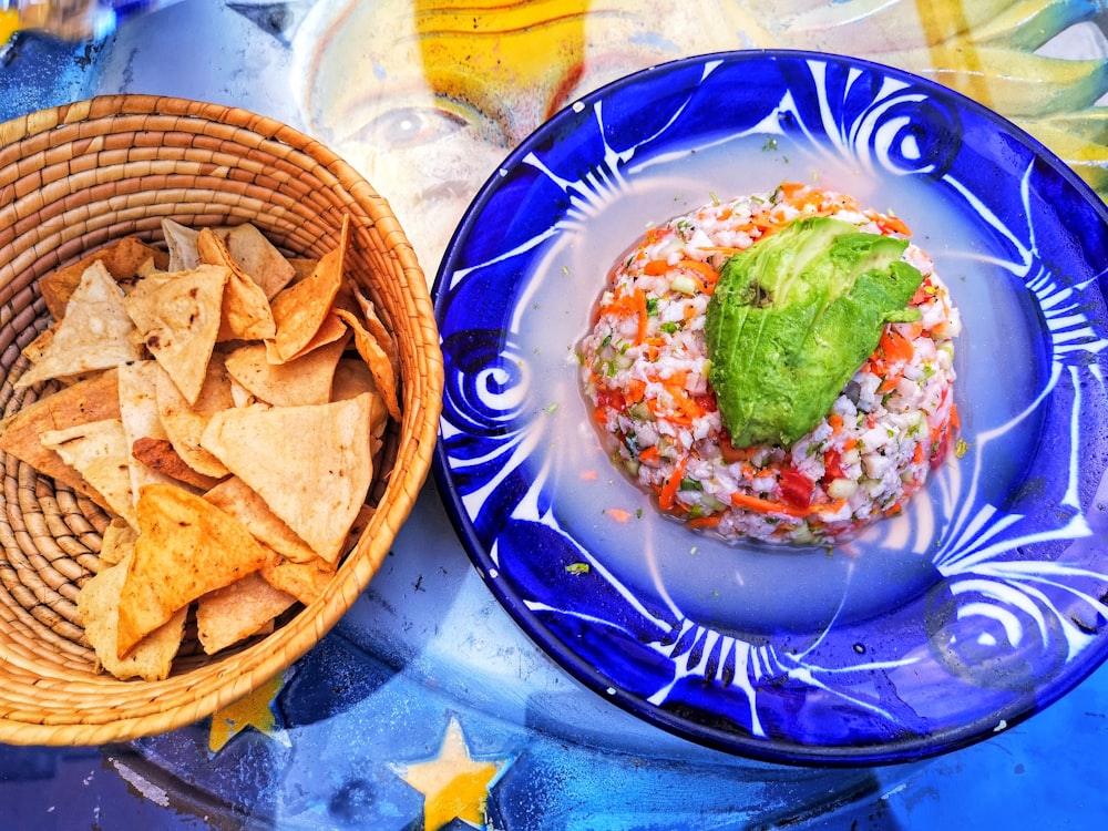 Plato marrón y verde sobre plato redondo de cerámica azul y blanca