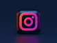 A three-dimensional Instagram logo icon with pink and orange gradient lighting