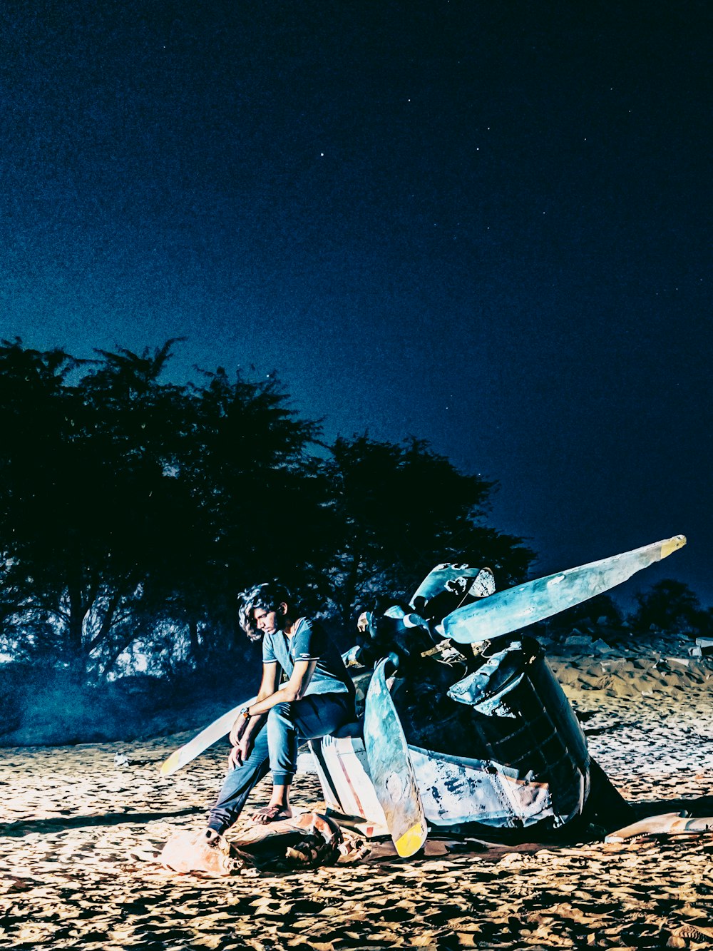 man and woman sitting on brown wooden log during night time