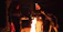 Group of people gathered around a campfire in the mountains during a survival weekend.