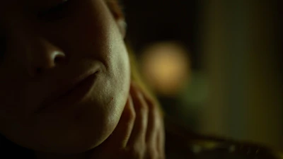 A close-up of a dermatologist in a sleek white coat examining a patient’s skin under soft, warm lighting.