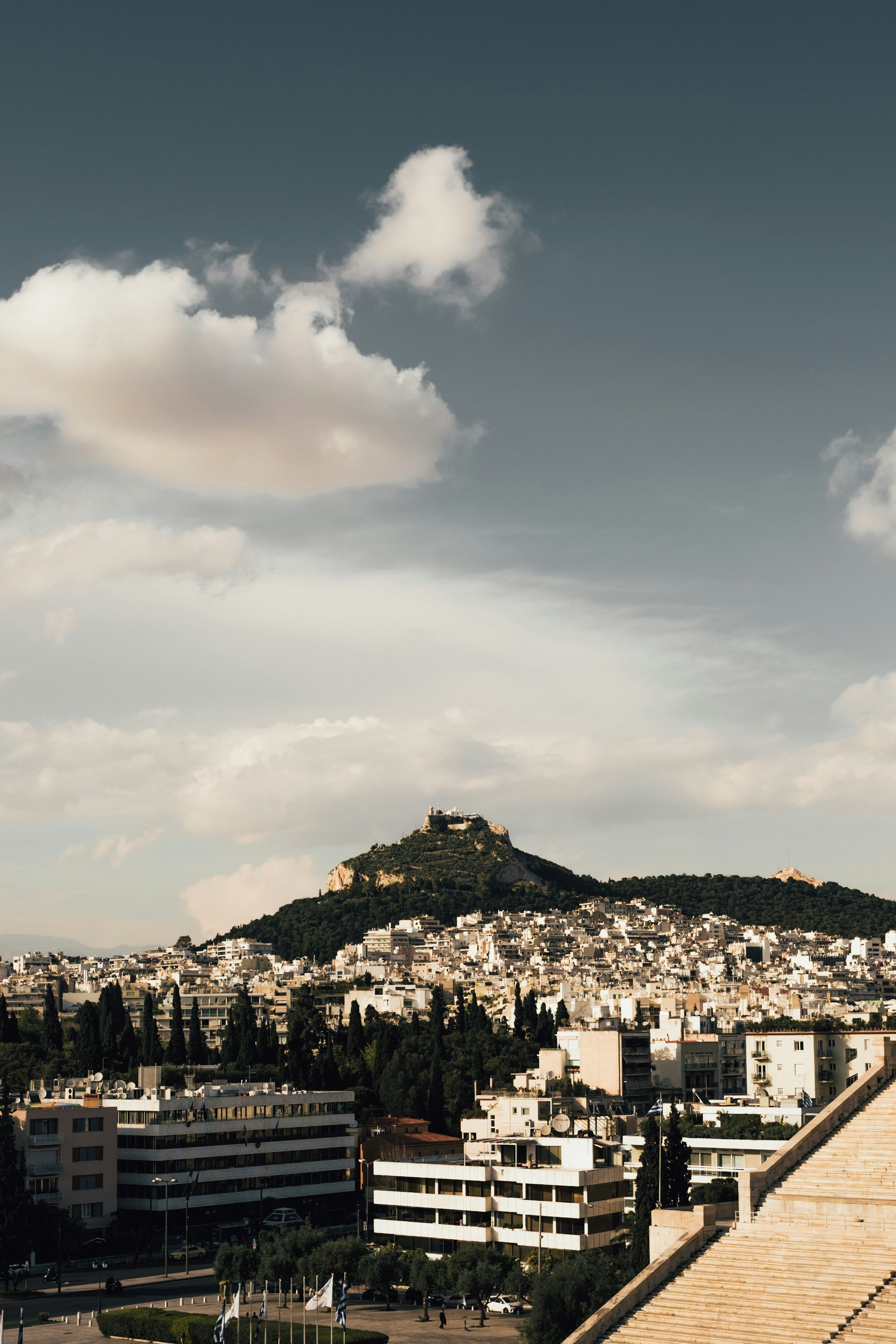 white concrete buildings on mountain under white clouds during daytime