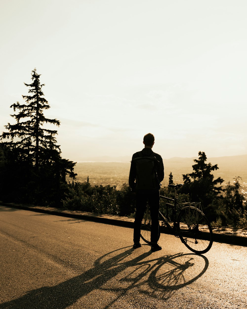 silhouette of man standing on road during daytime