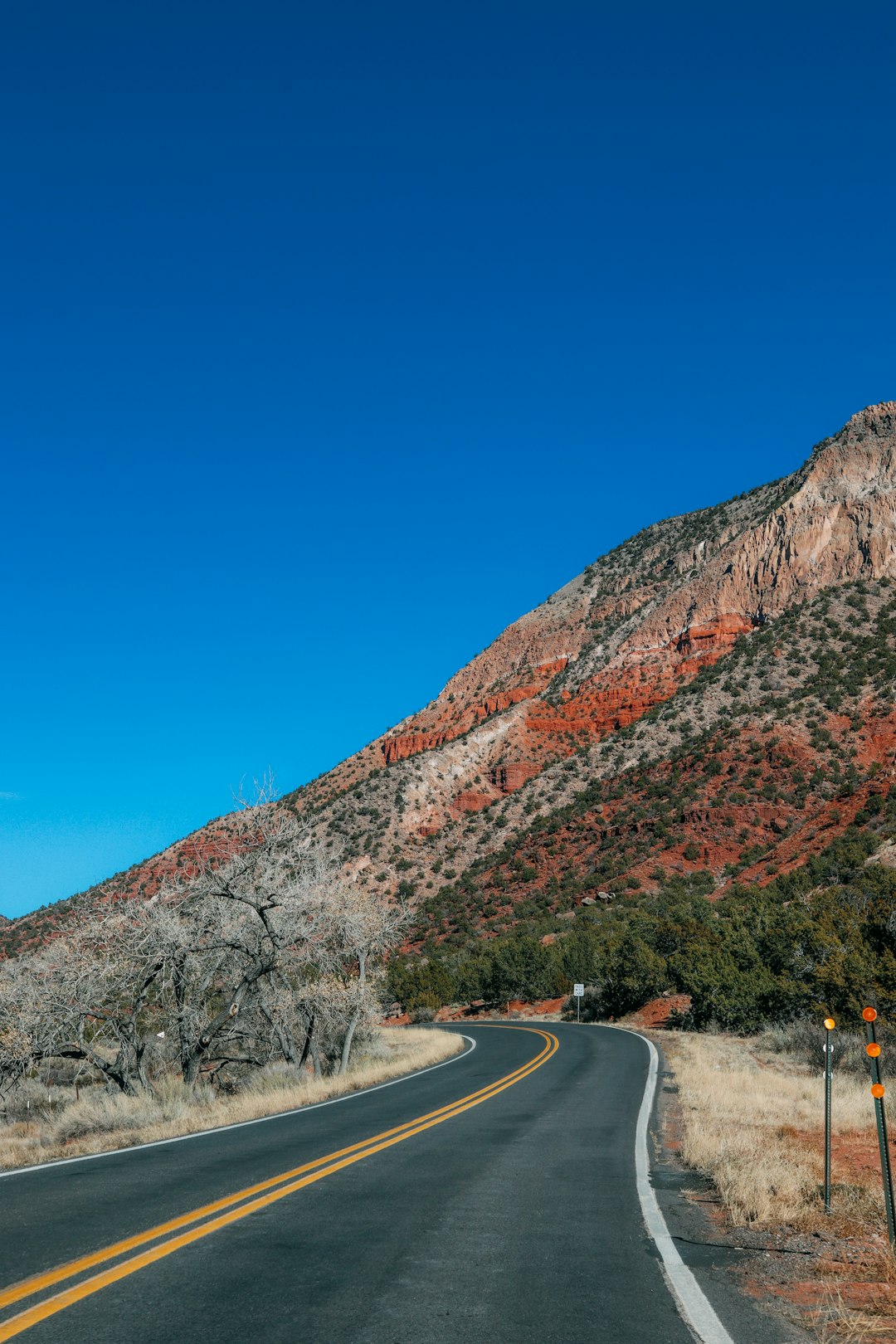 gray asphalt road near brown mountain during daytime