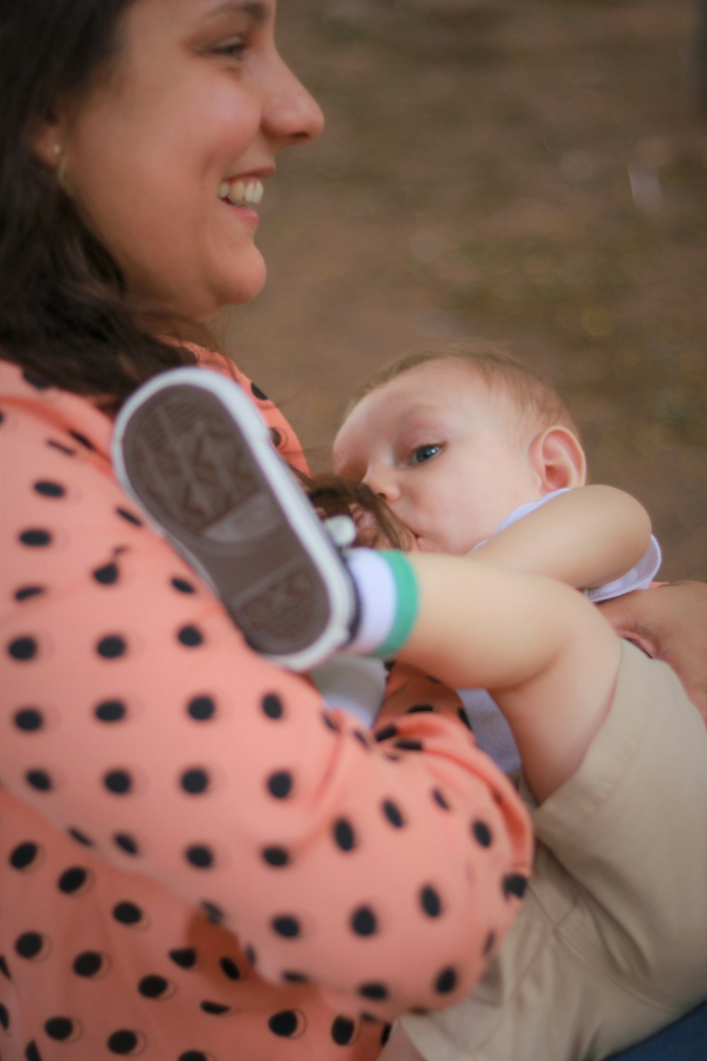 woman in white and red polka dot shirt carrying baby