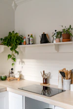 Electrician carefully connecting a modern induction cooktop in a bright kitchen.