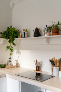 Electrician carefully connecting a modern induction cooktop in a bright kitchen.