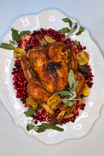 Close-up of a golden turmeric-glazed turkey alternative surrounded by fresh herbs.