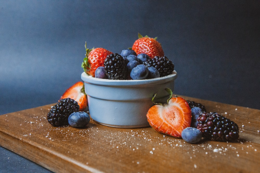 strawberries and blueberries in white ceramic bowl