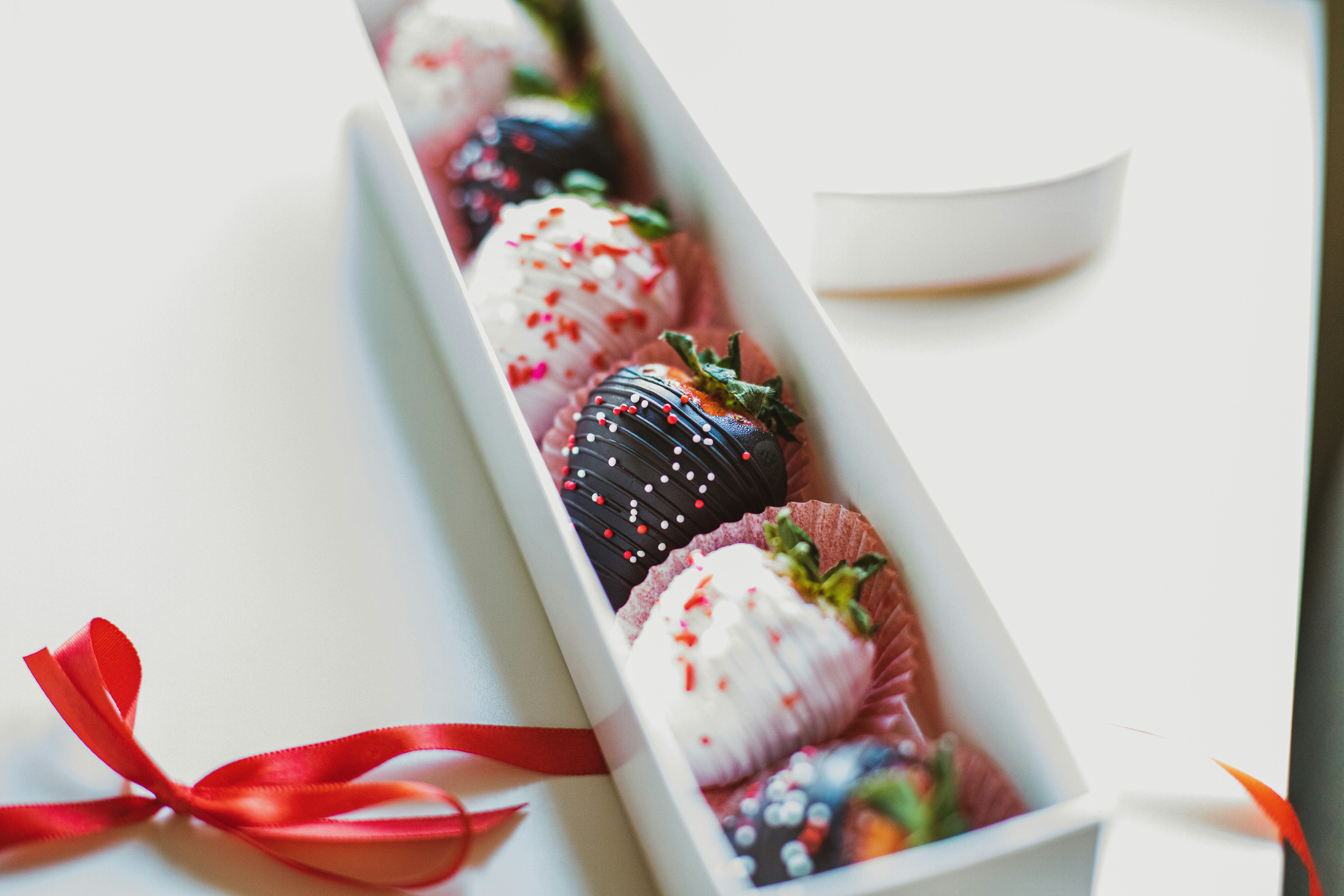 sliced strawberries and blueberries in white ceramic bowl