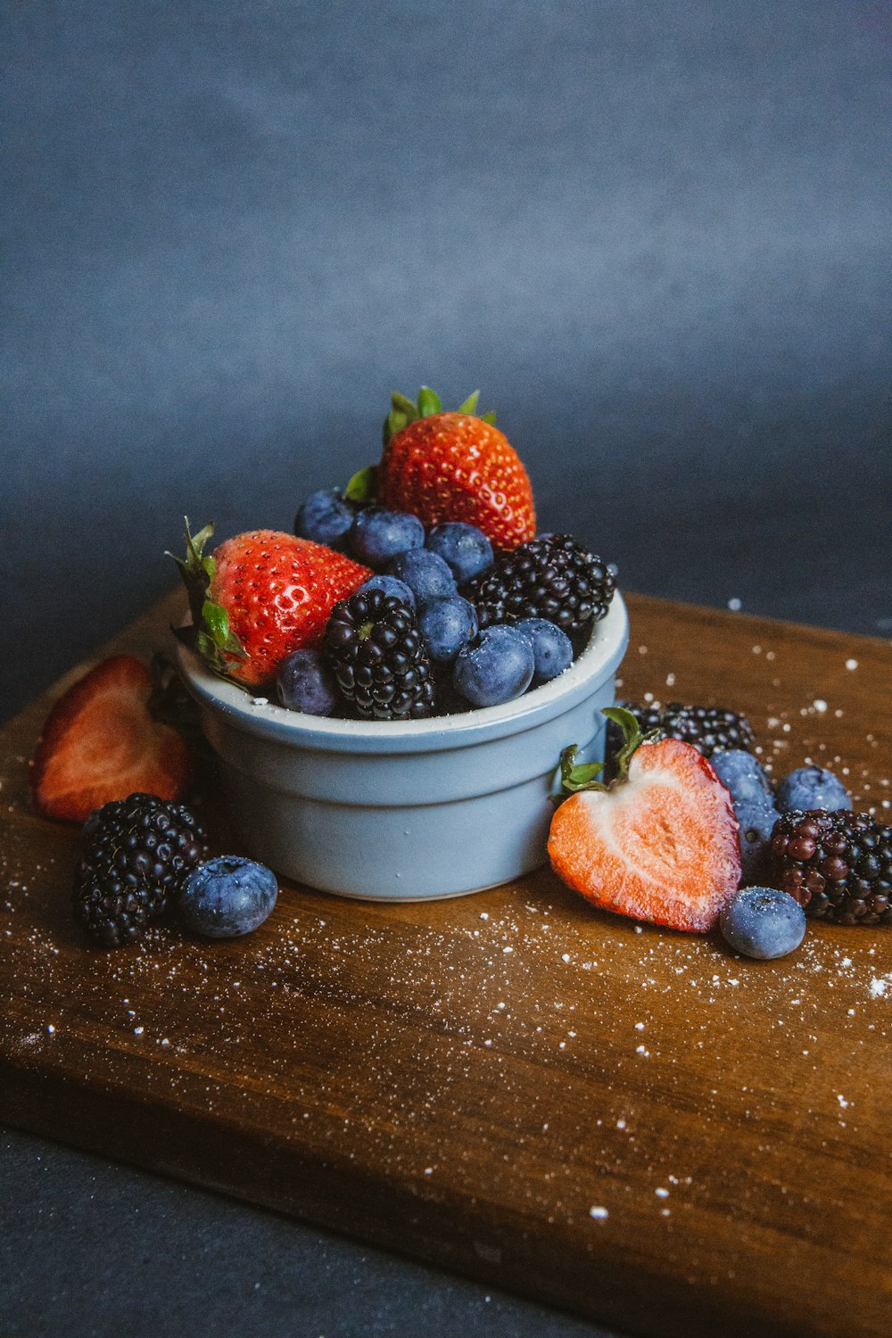 strawberries and blueberries in white ceramic bowl