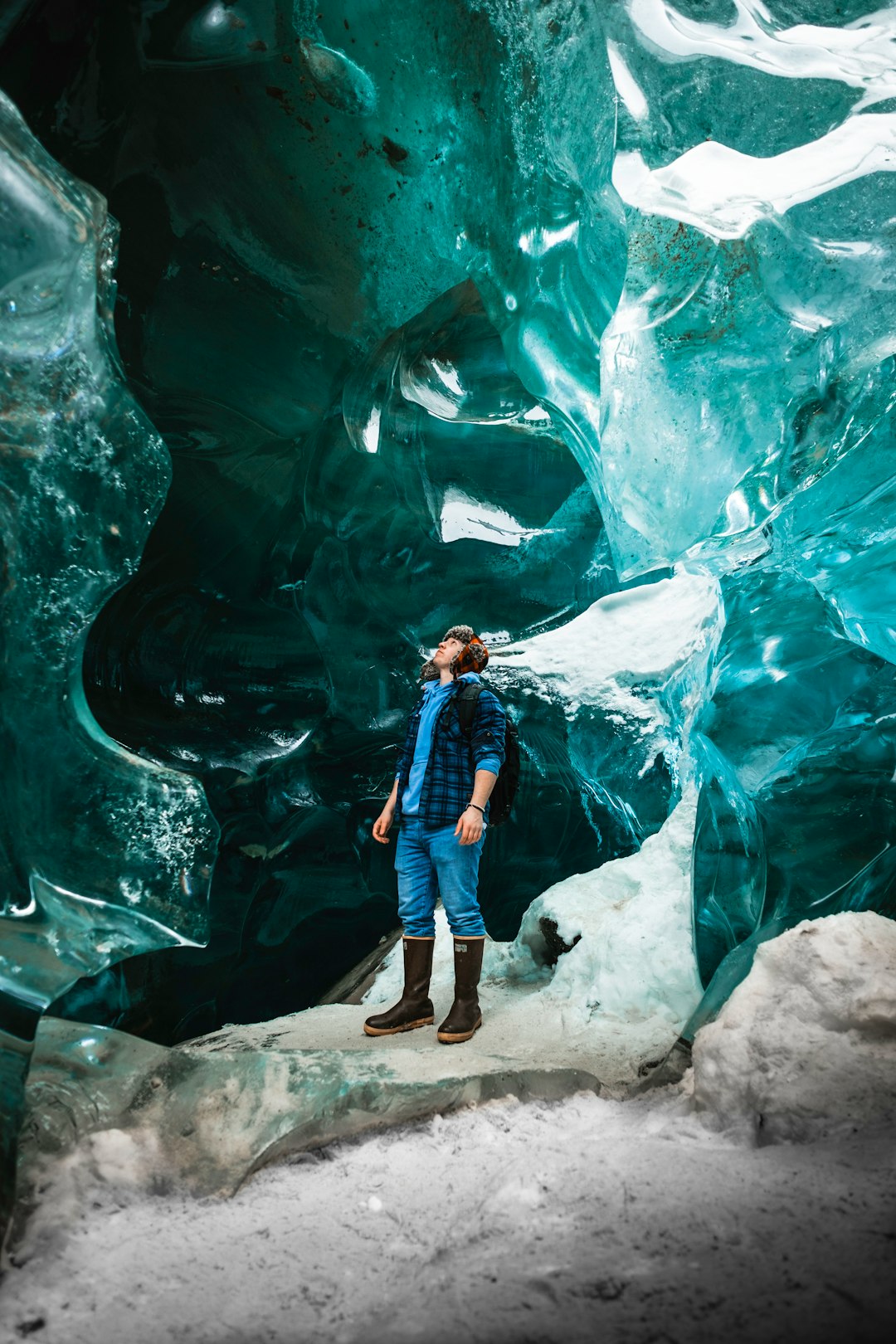 woman in blue and black jacket standing on rock