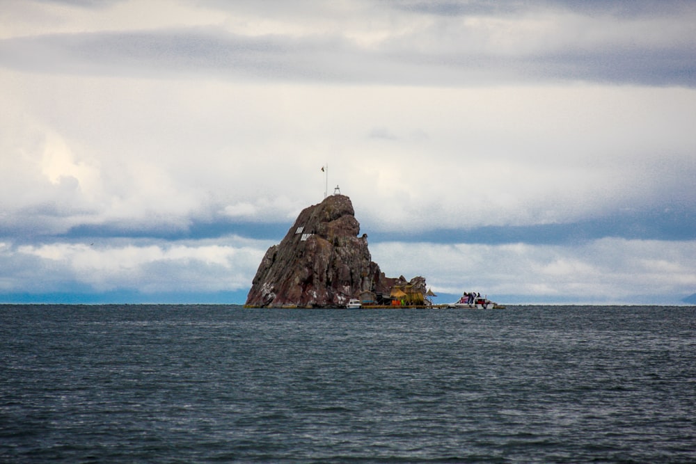 brown rock formation on body of water during daytime