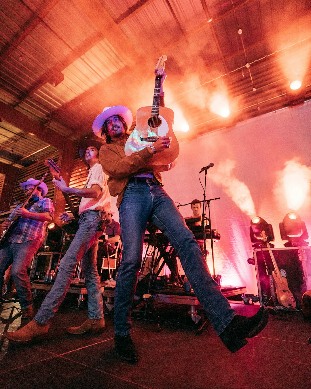 man in blue denim jeans playing guitar