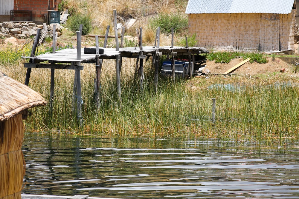 brown wooden fence near body of water during daytime