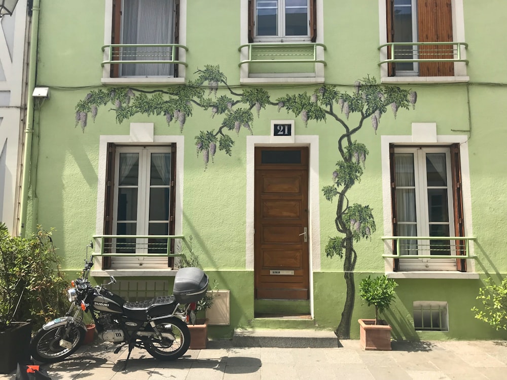 black motorcycle parked beside brown wooden door