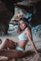 woman in white bikini sitting on rock